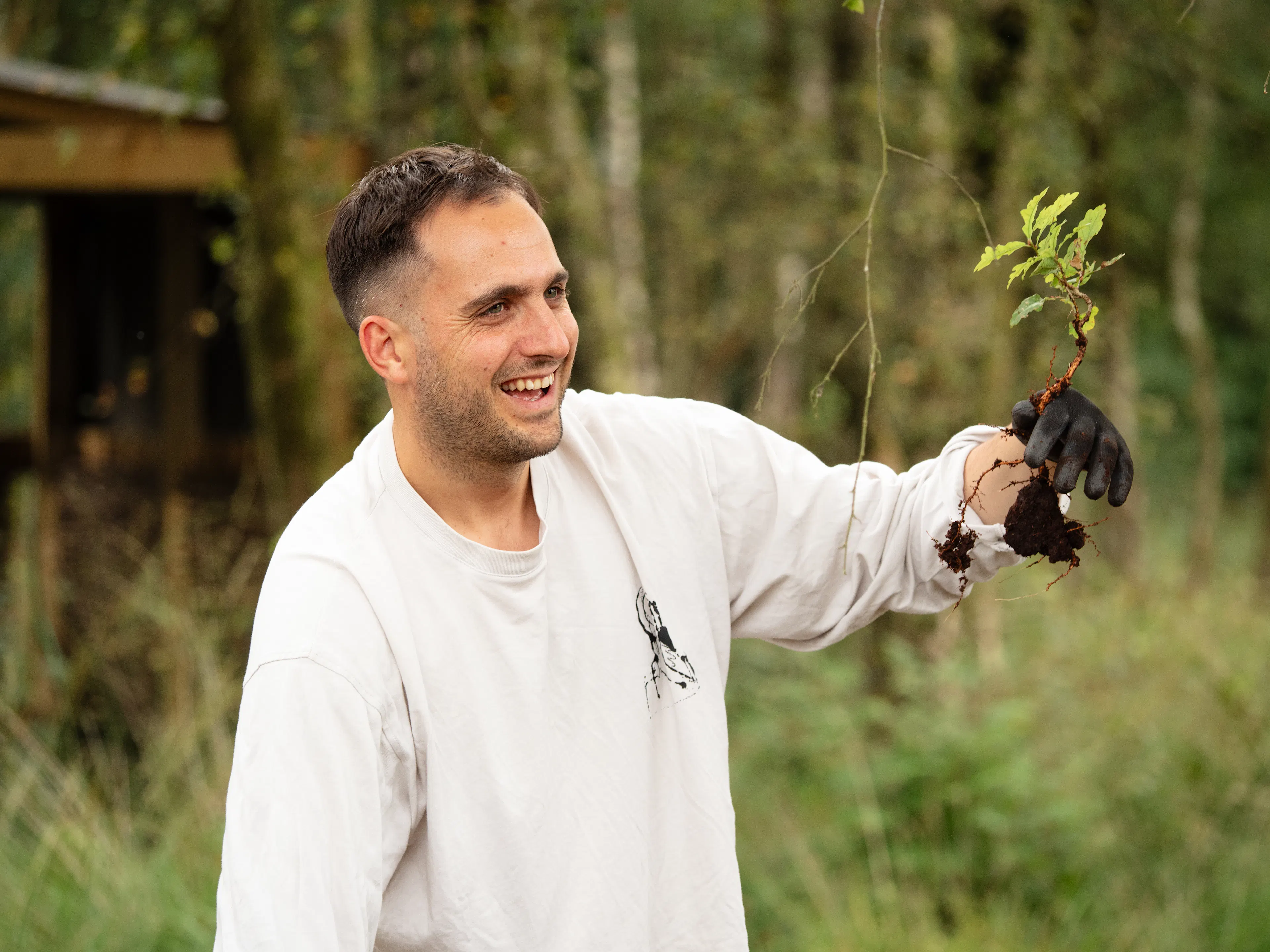 Ticket Tailor team member holding up plant in a field – working for Cumbria Wildlife Trust