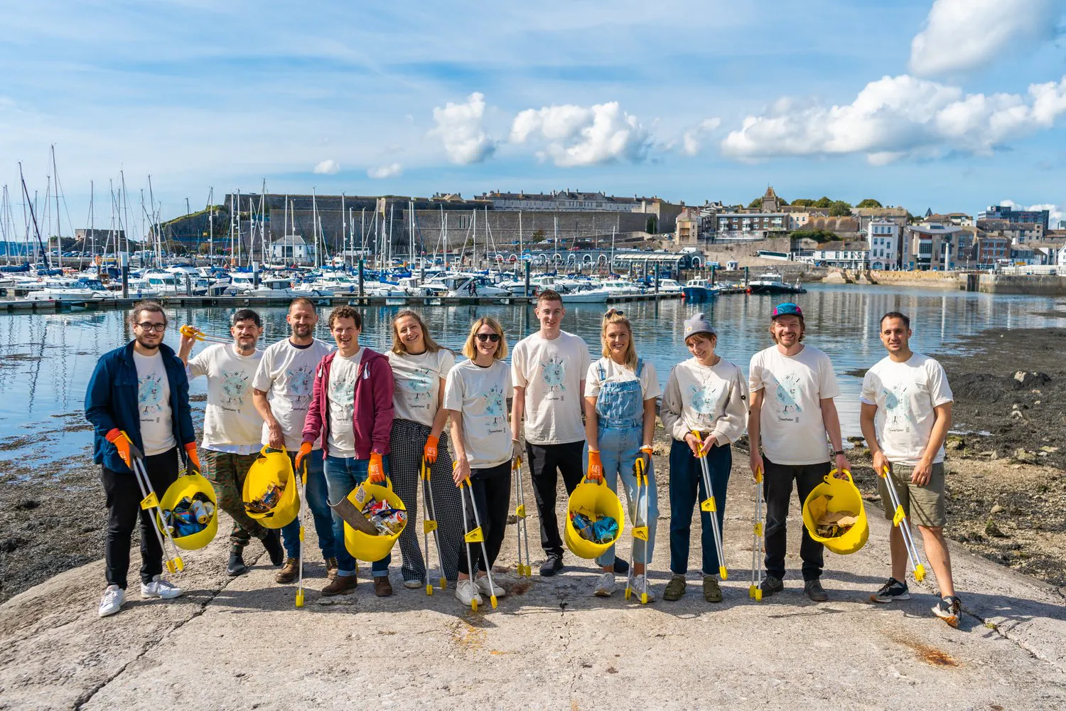 a group of people holding buckets with rubbish in it.