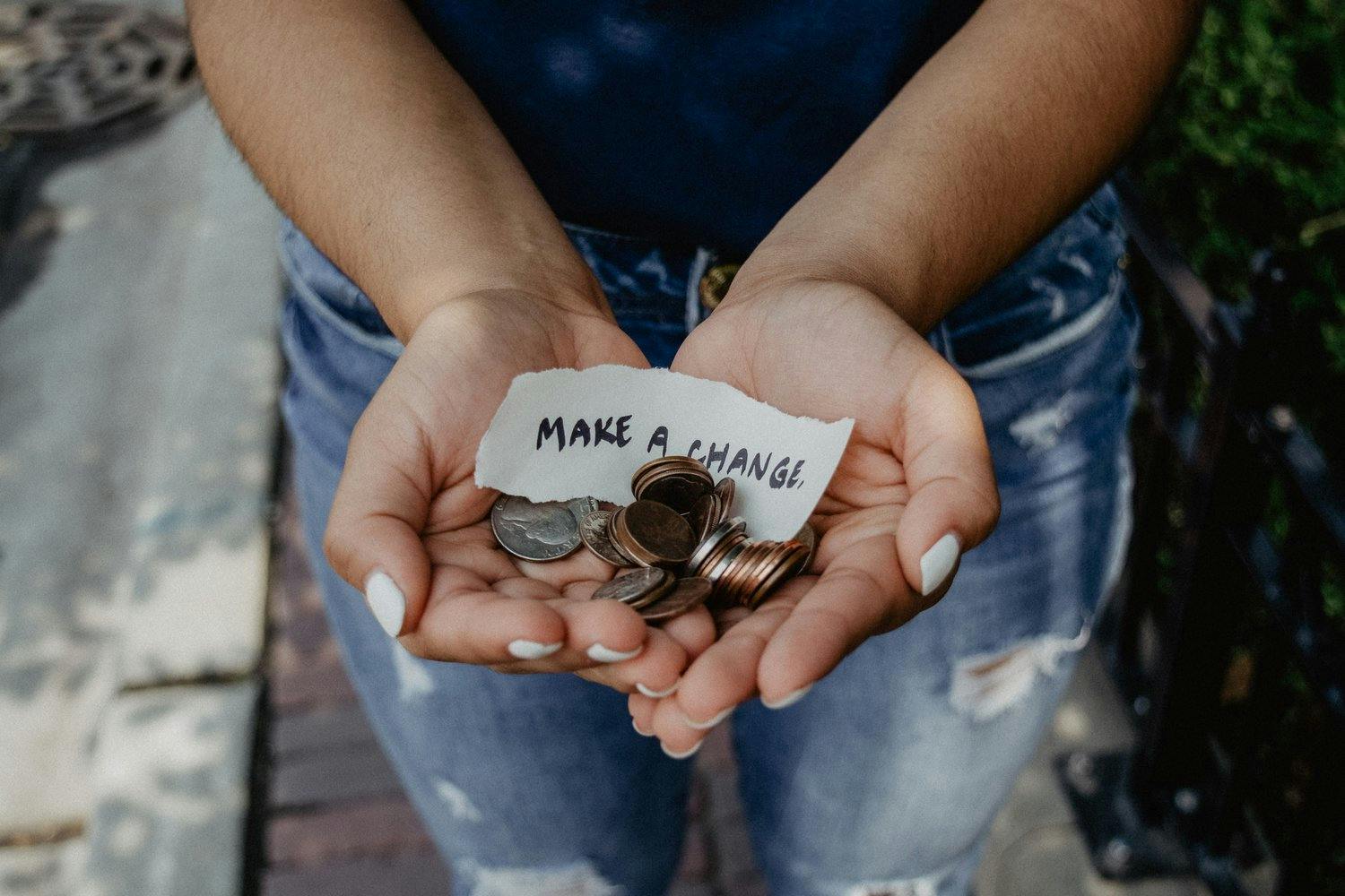 a person holding a pile of coins