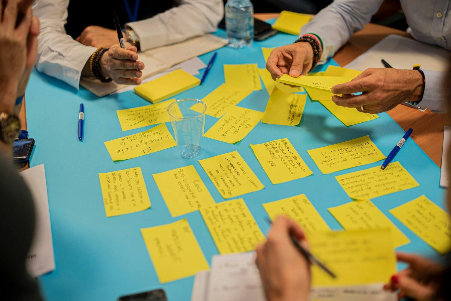 a group of people sitting around a table with yellow sticky notes