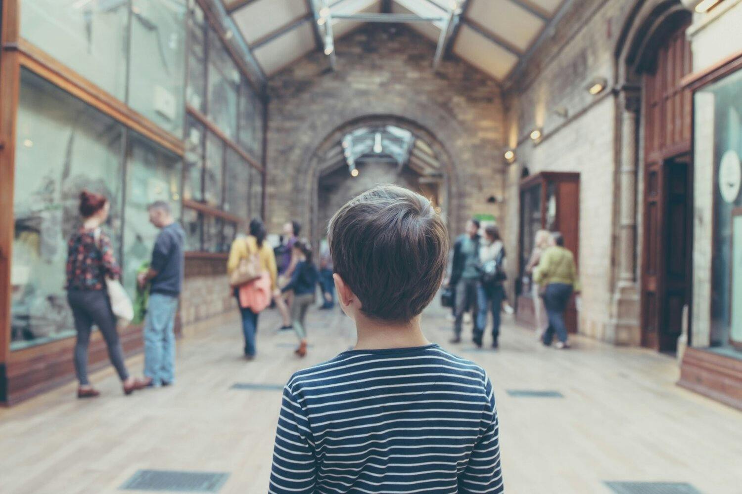 a child looking at a group of people in a building