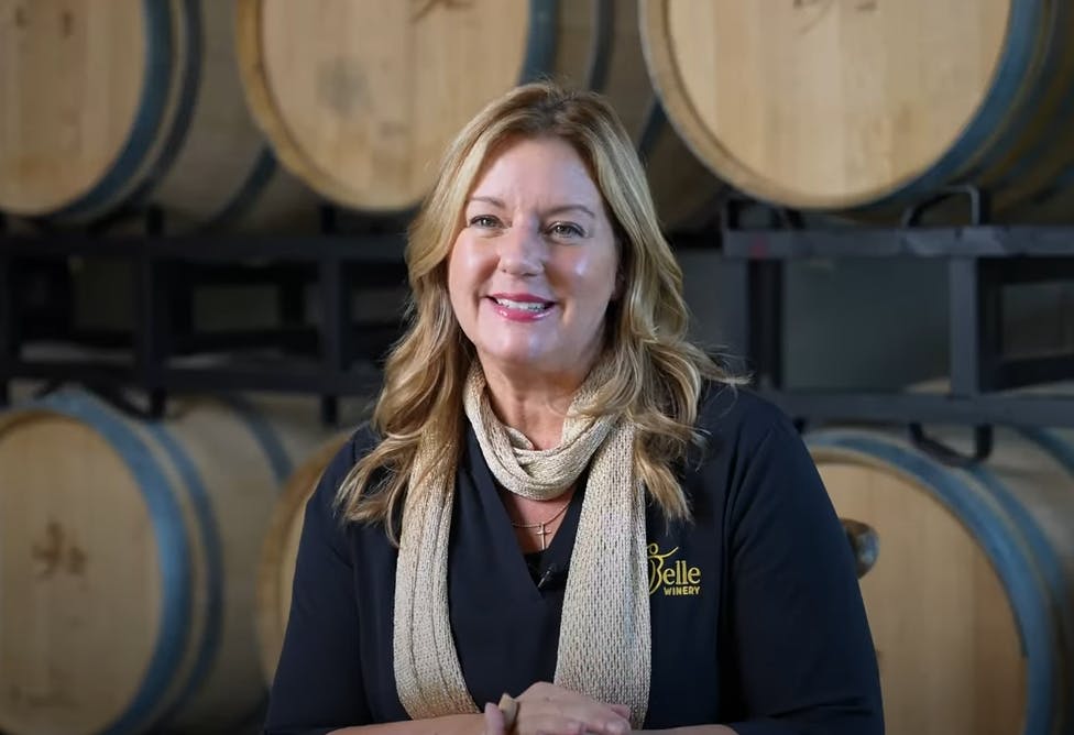 Amy LaBelle being interviewed with wine barrels in background