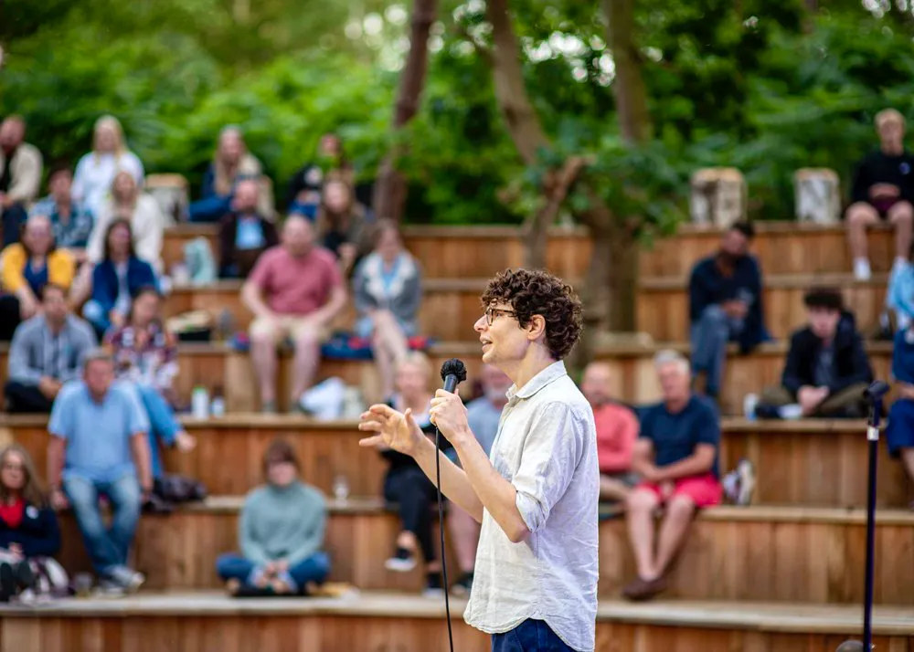 a person speaking into a microphone in front of a crowd