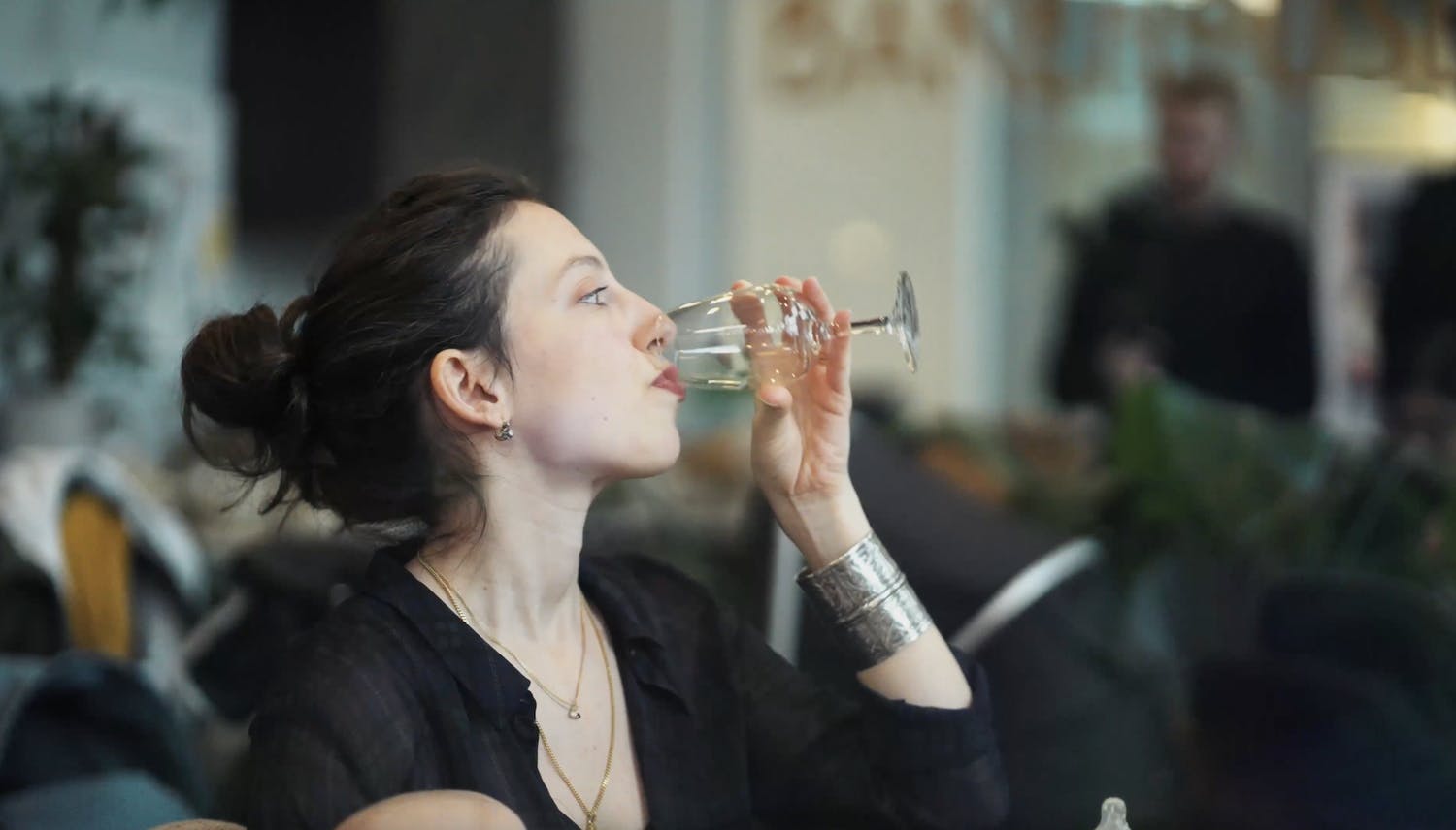 Lady with dark hair drinking a glass on wine