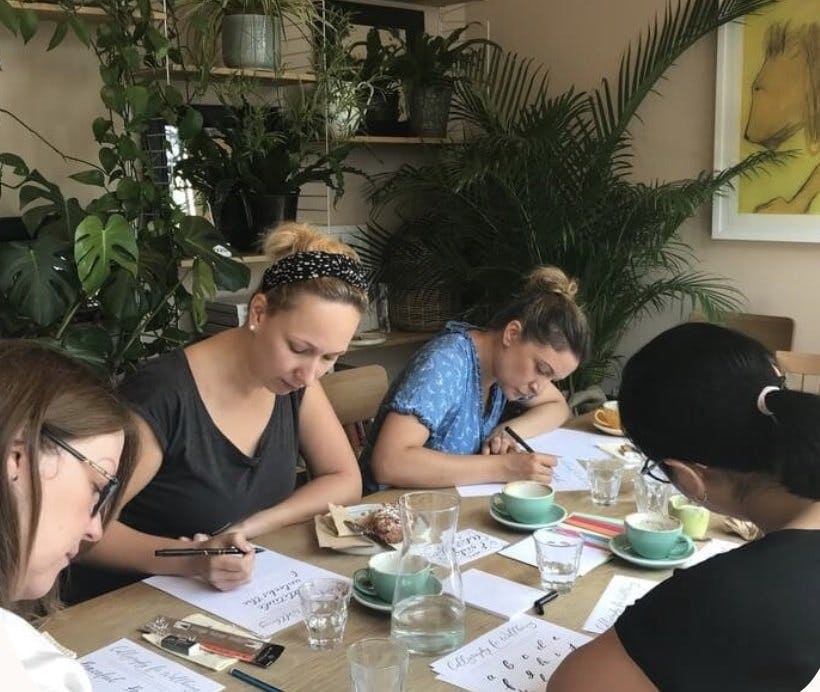 a group of women sitting at a table writing