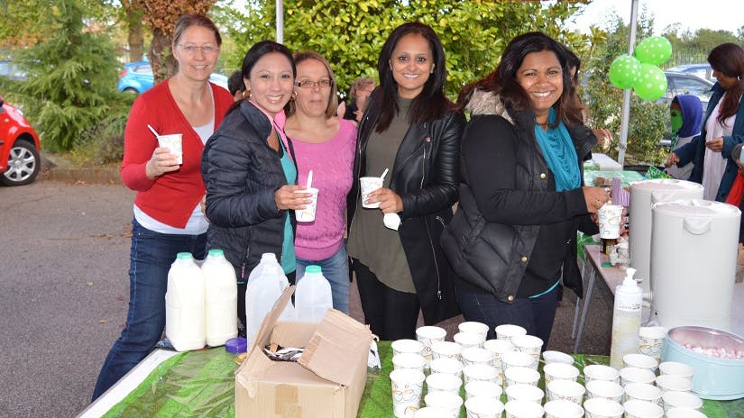 a group of women standing next to a table with drinks