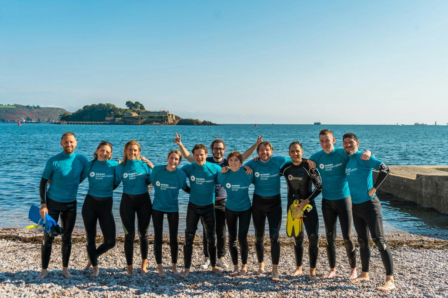 a group of people posing for a photo near ocean