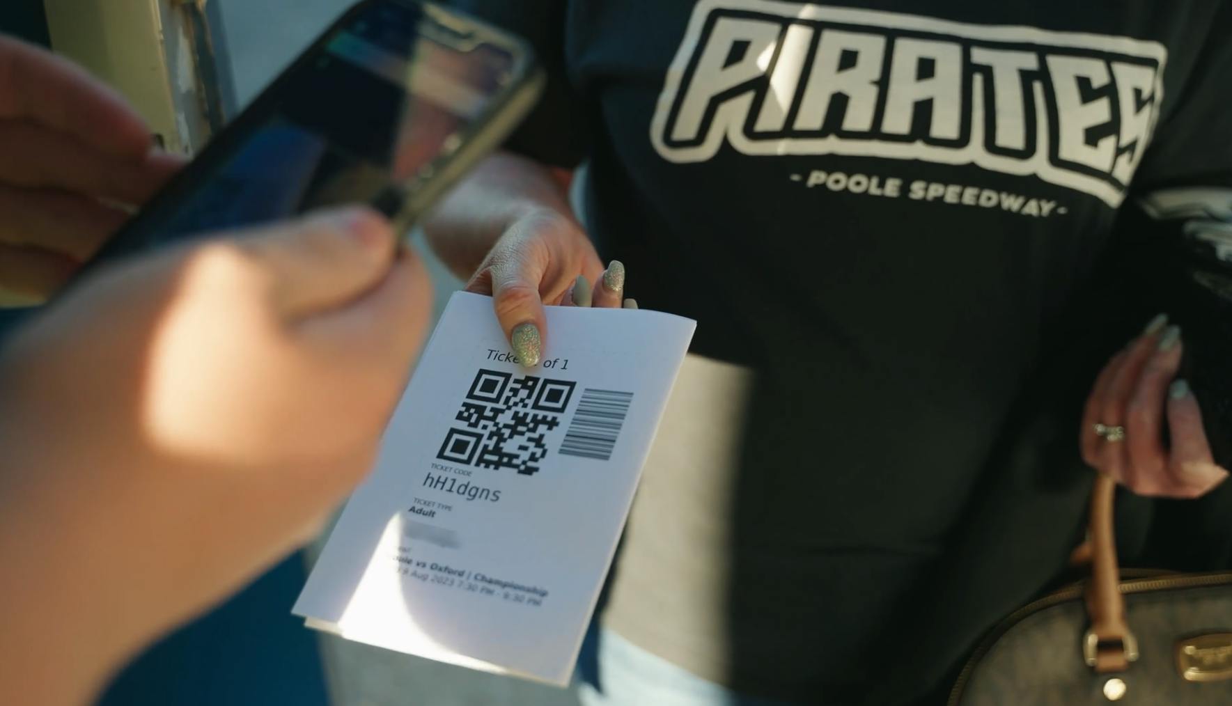 Ticket Scanning at Poole Speedway attendee wearing Pirates top and holding printed ticket