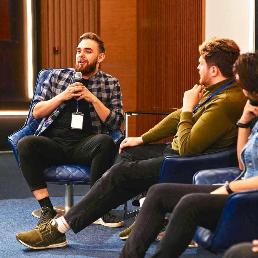 Men speaking on panel at event