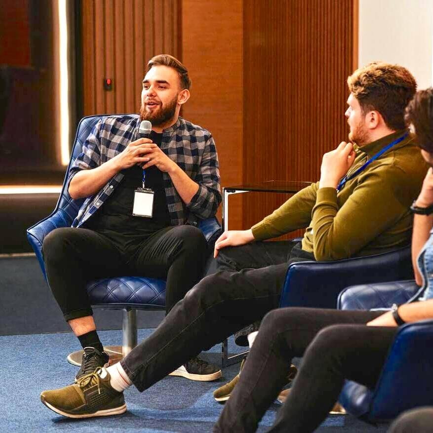 Men speaking on panel at event