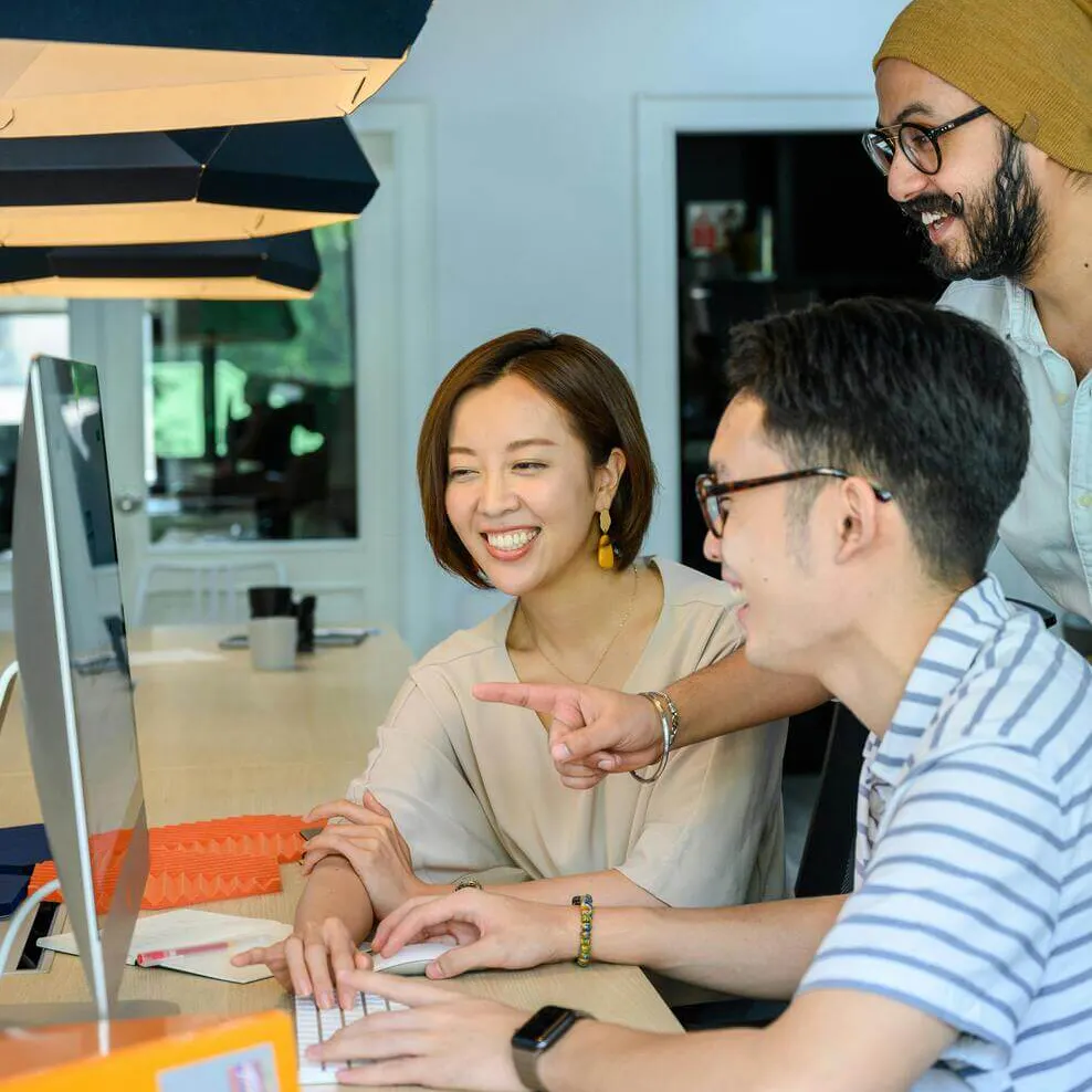 People smiling while looking at computer screen