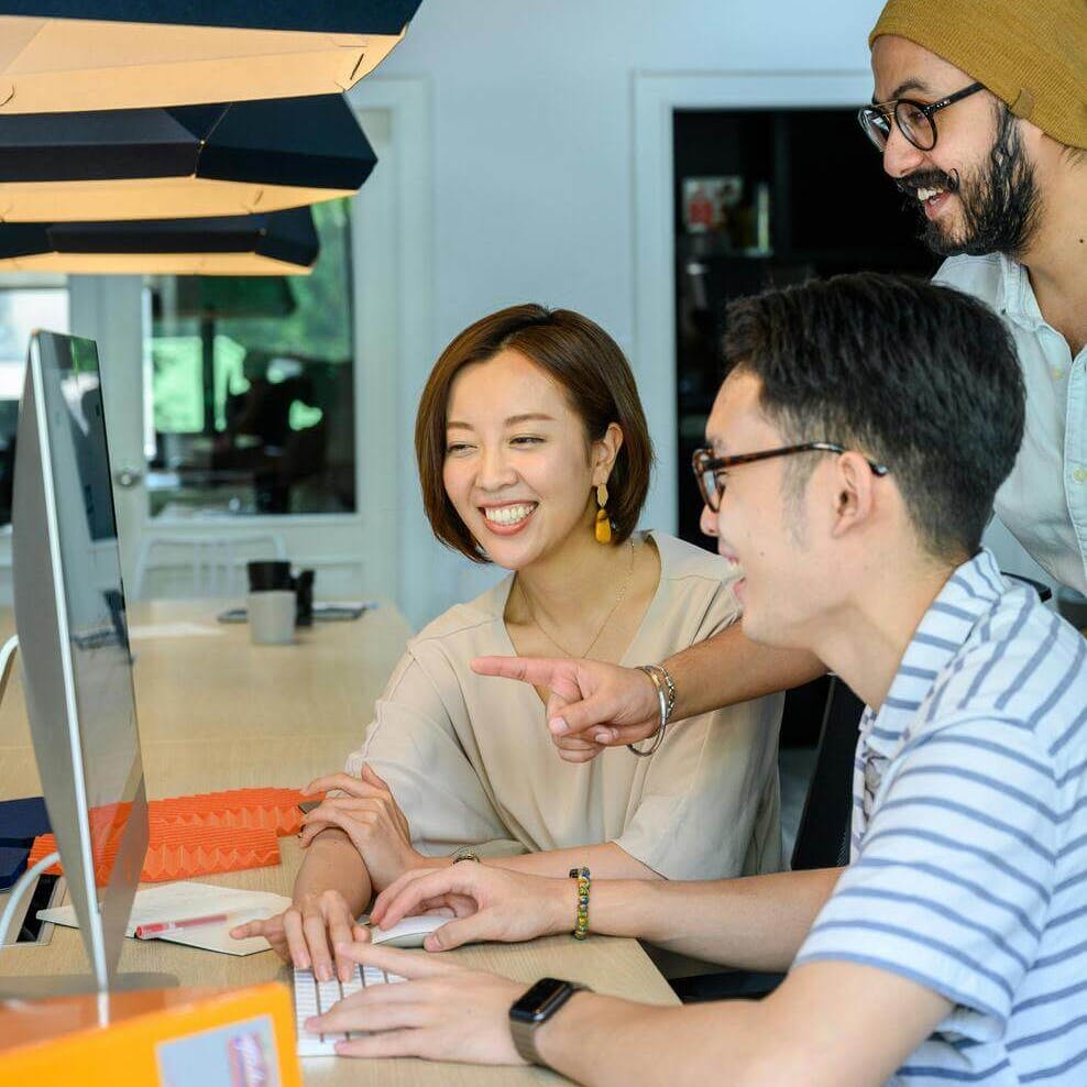People smiling while looking at computer screen