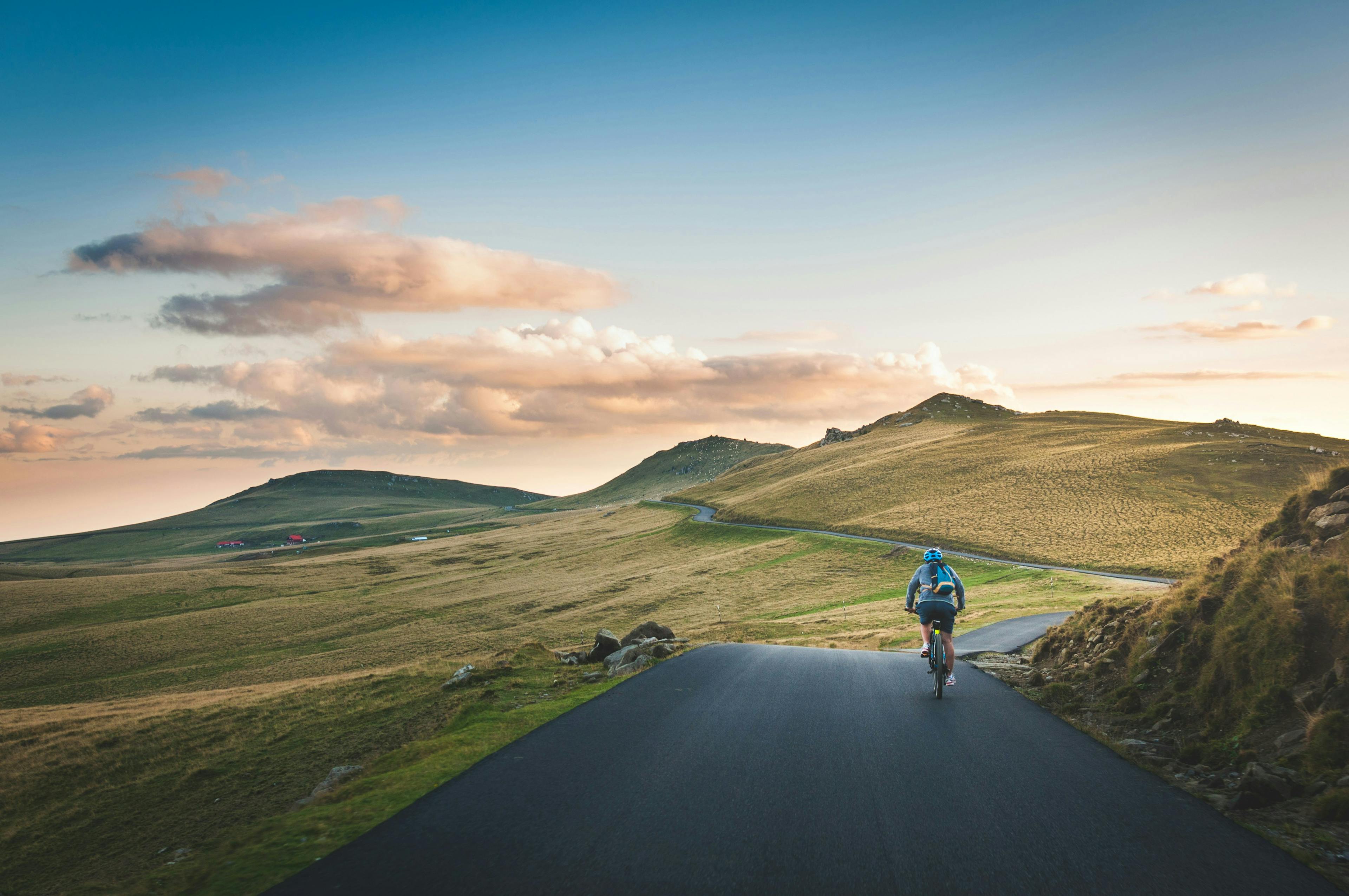 Person cycling in hilly landscape