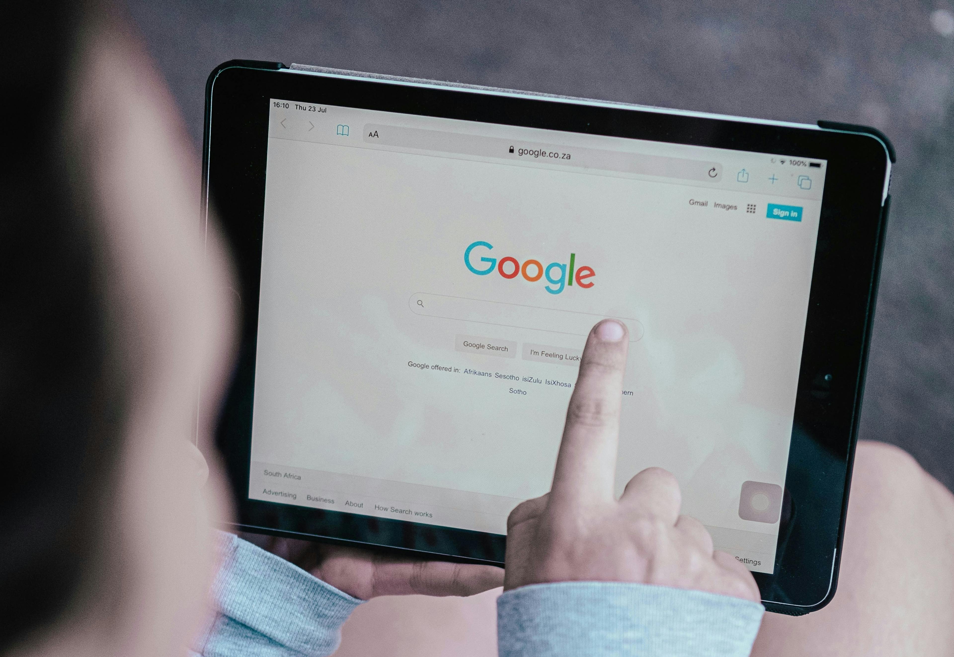 ipad with google search bar and person clicking