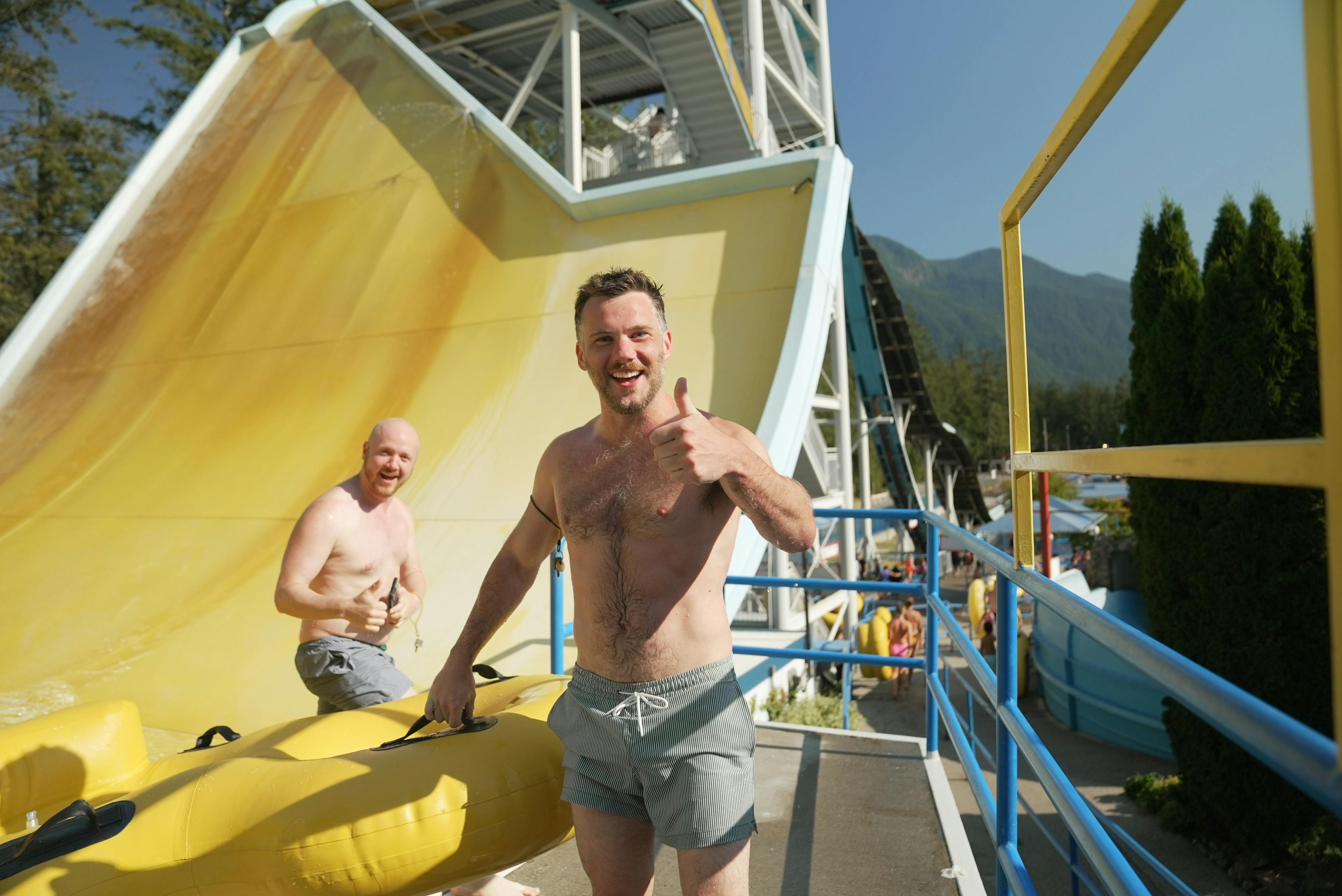 Cultus Lake Waterpark Two men getting off slide, thumbs up