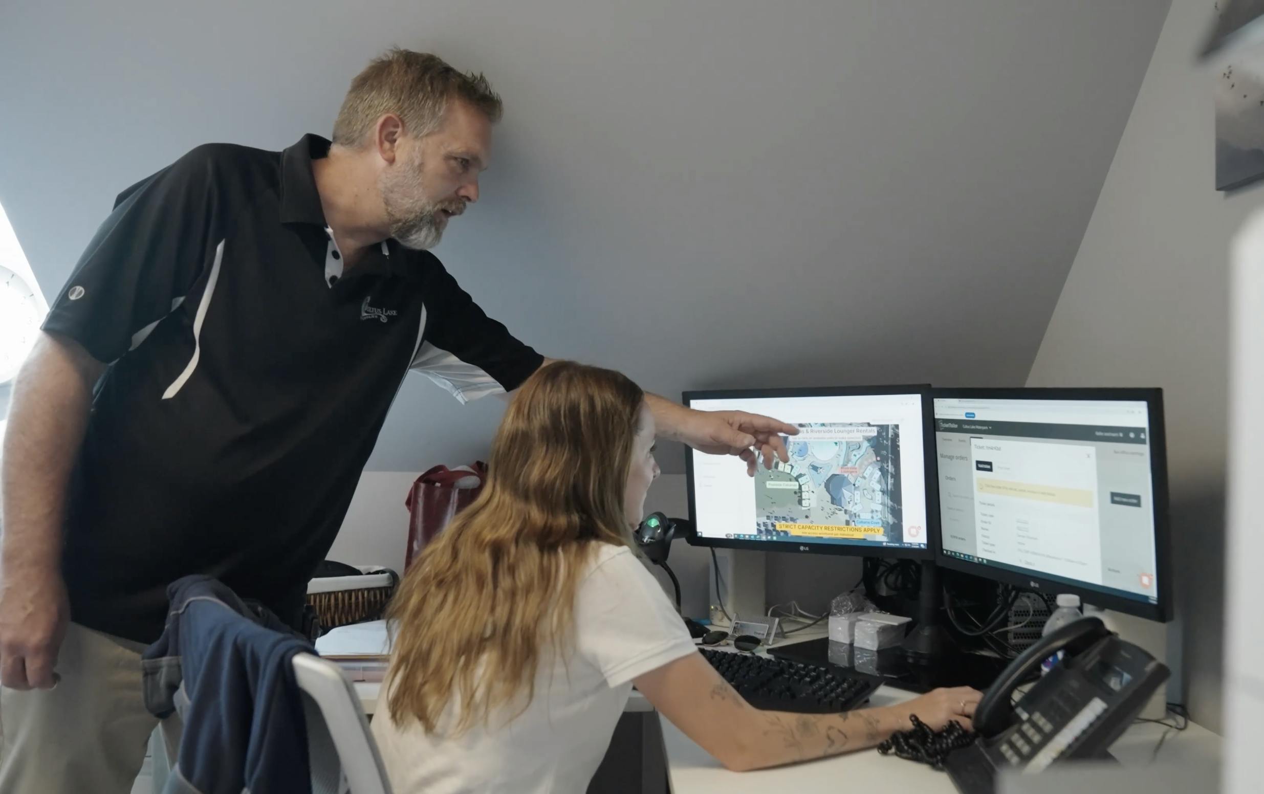 Cultus Lake Waterpark Andrew showing staff how to manage ticketing on two computer screens