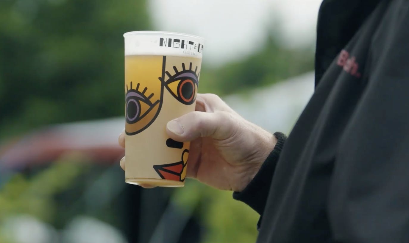 hand holding compostable cup with beer