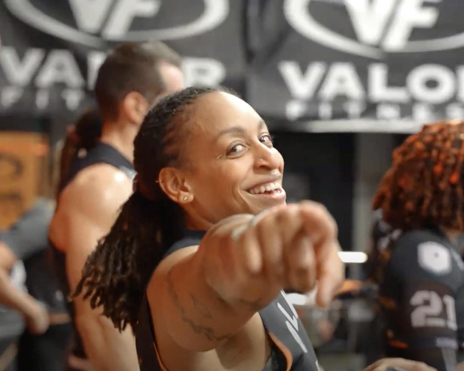 United Grid League female athlete grinning and pointing at camera