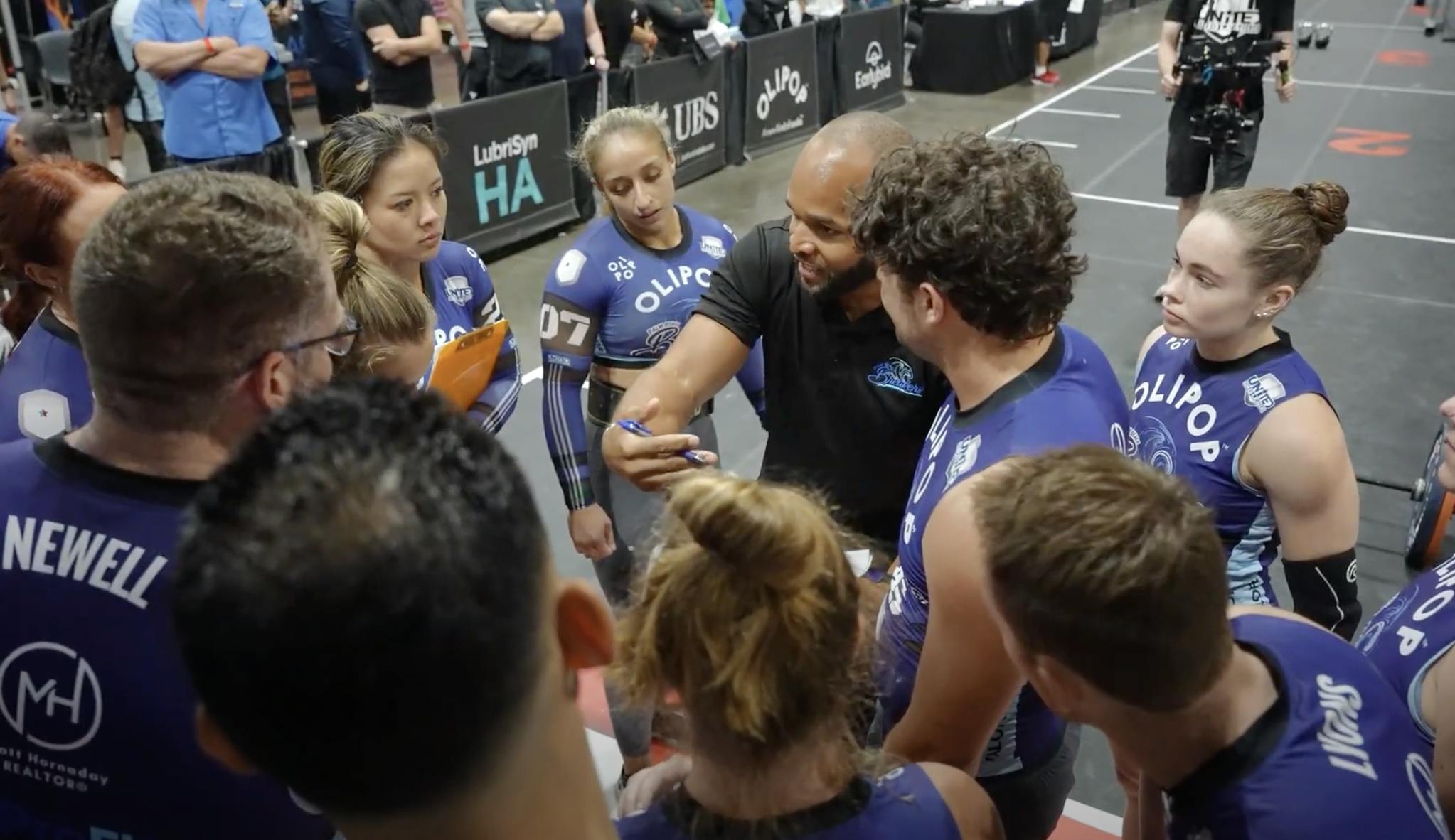 United Grid League team huddle with coach giving strategic advice