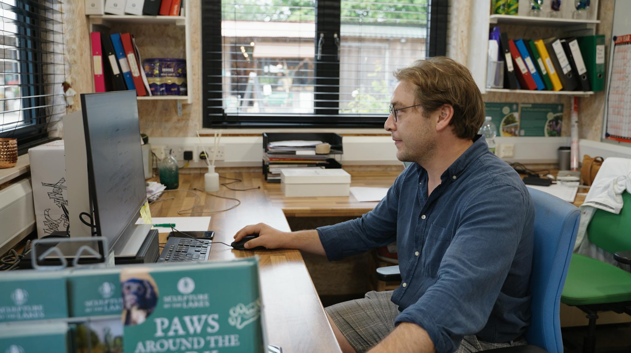 Sculpture by the Lakes Operations Manger Tom at a computer