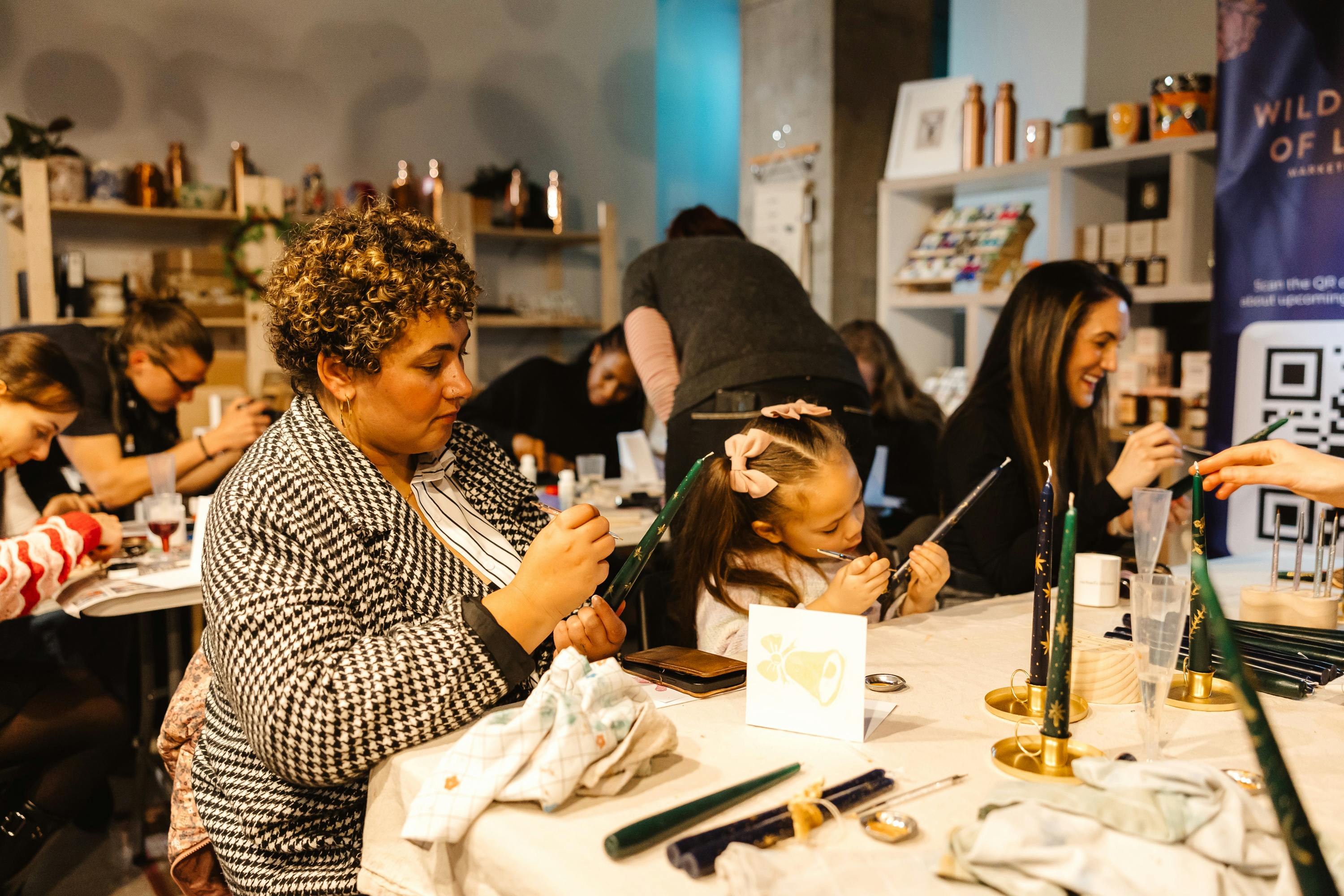 Lou wildflowers of London, people sat at table painting candles
