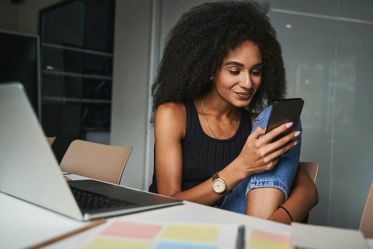 Woman working on laptop and phone