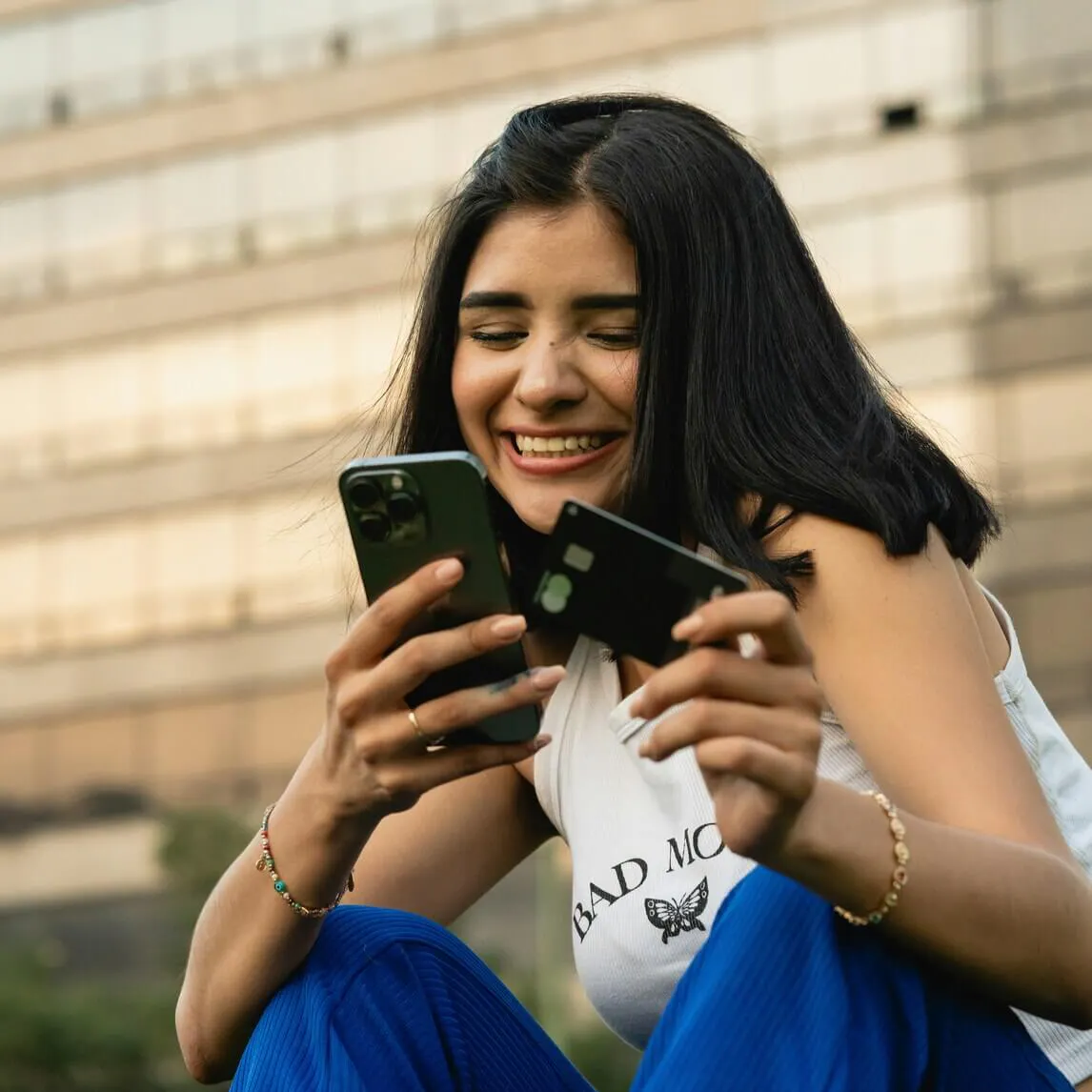 Woman smiling on phone with payment card