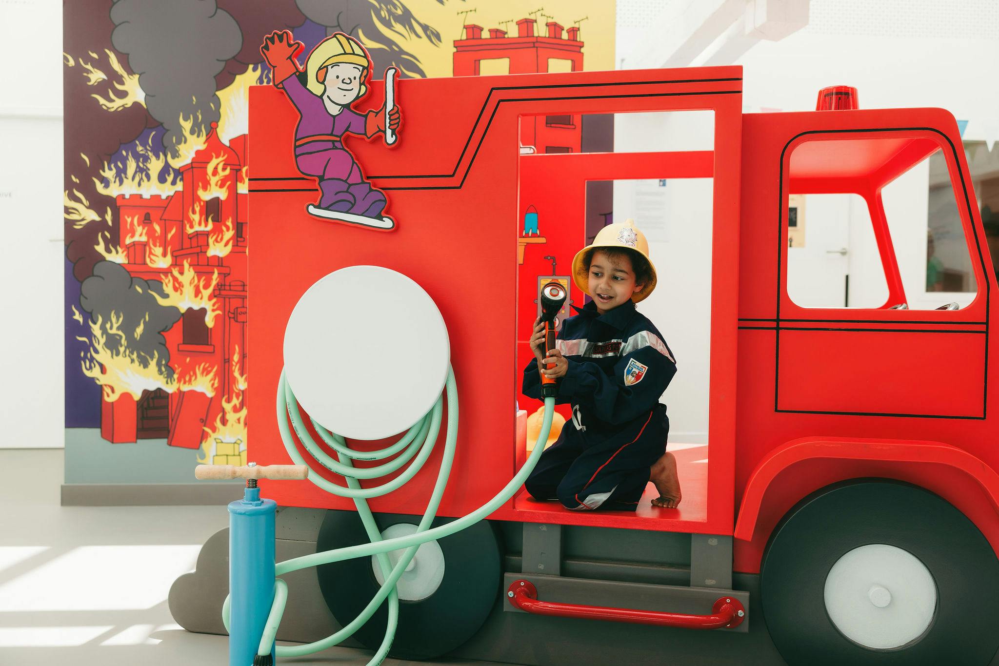 Boy dressed as fireman at La Maison des Histoires