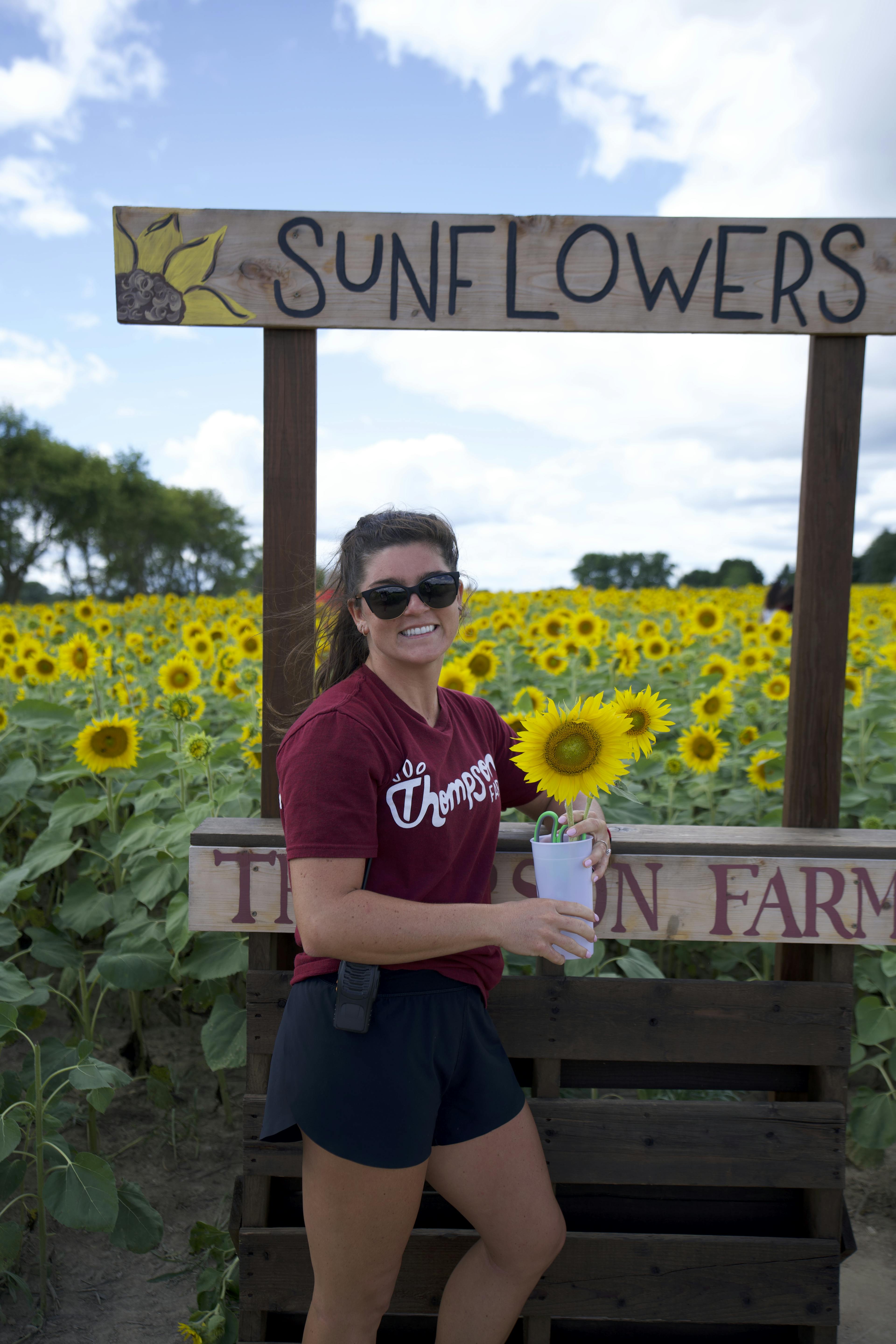 Sunflower stand and Halie at Thompson Farm