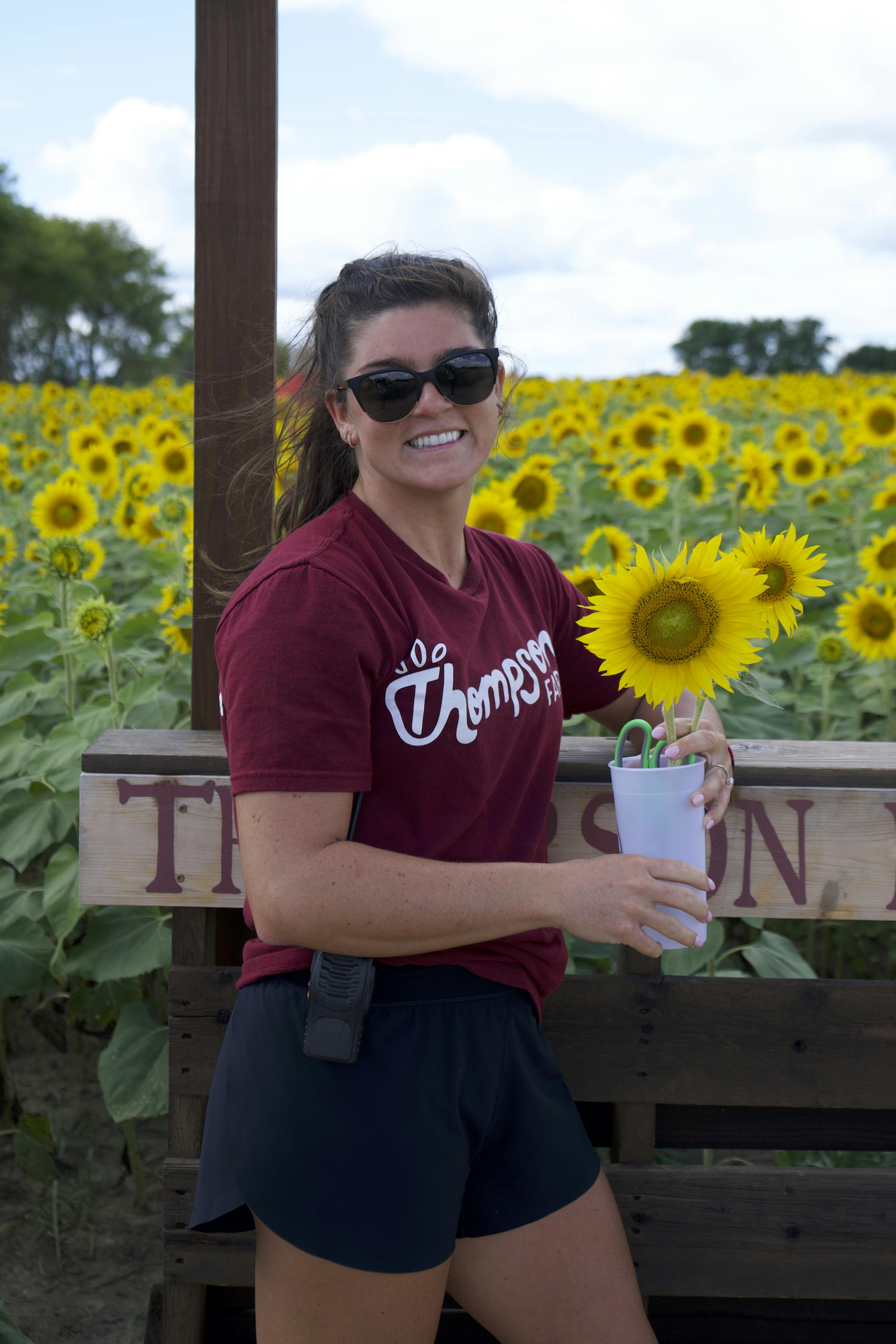 Sunflower stand and Halie at Thompson Farm