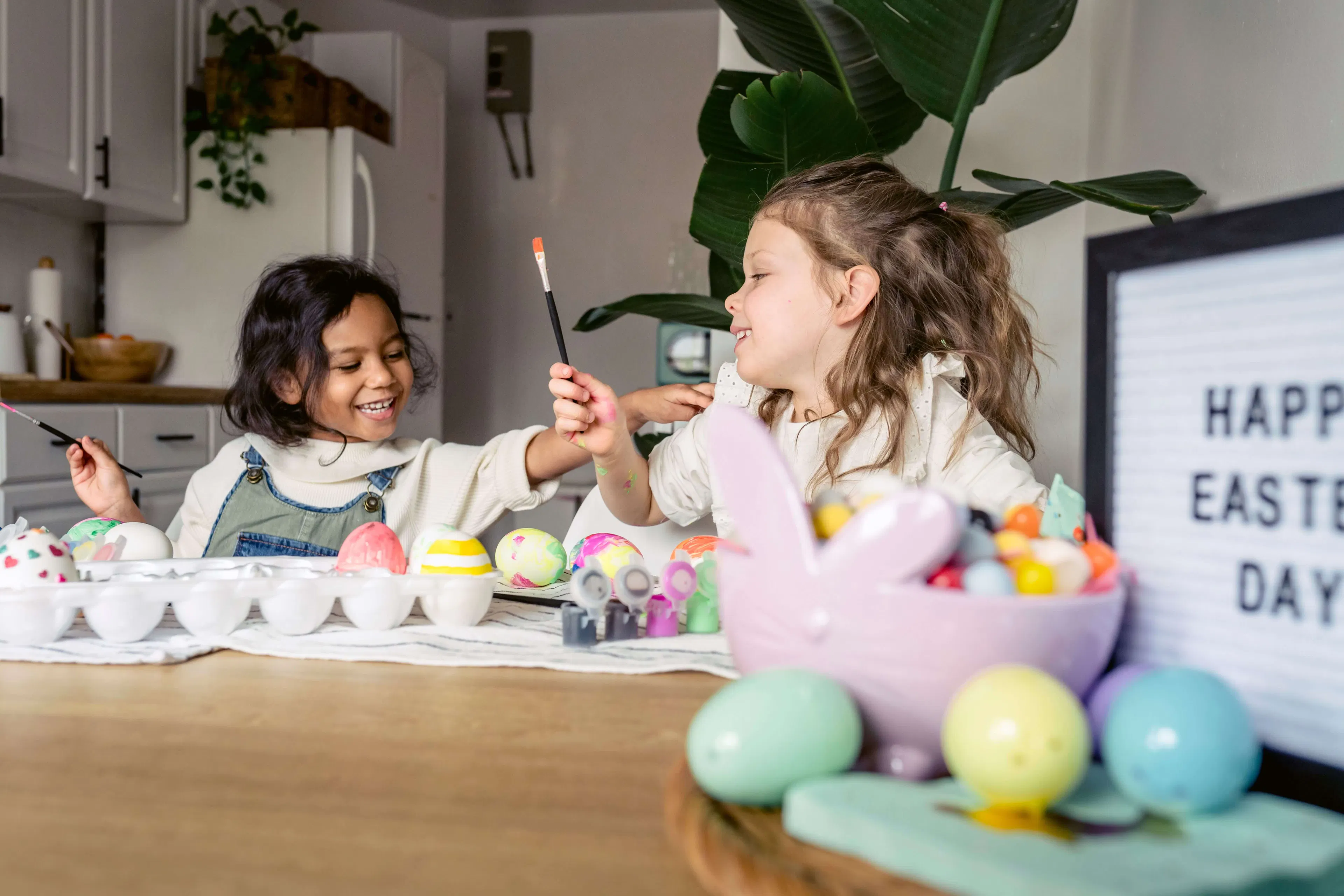 2 children painting easter eggs