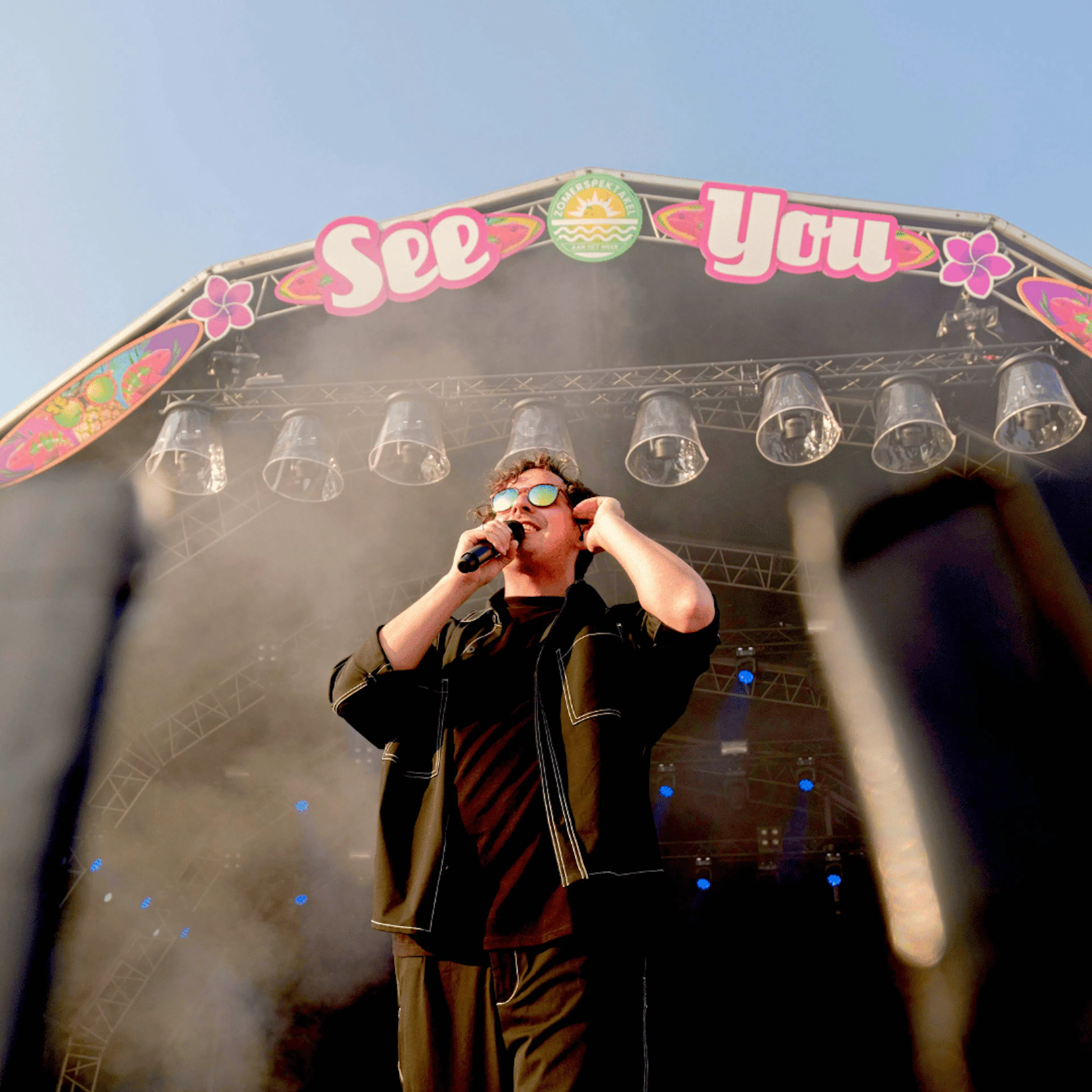 man singing on stage at festival