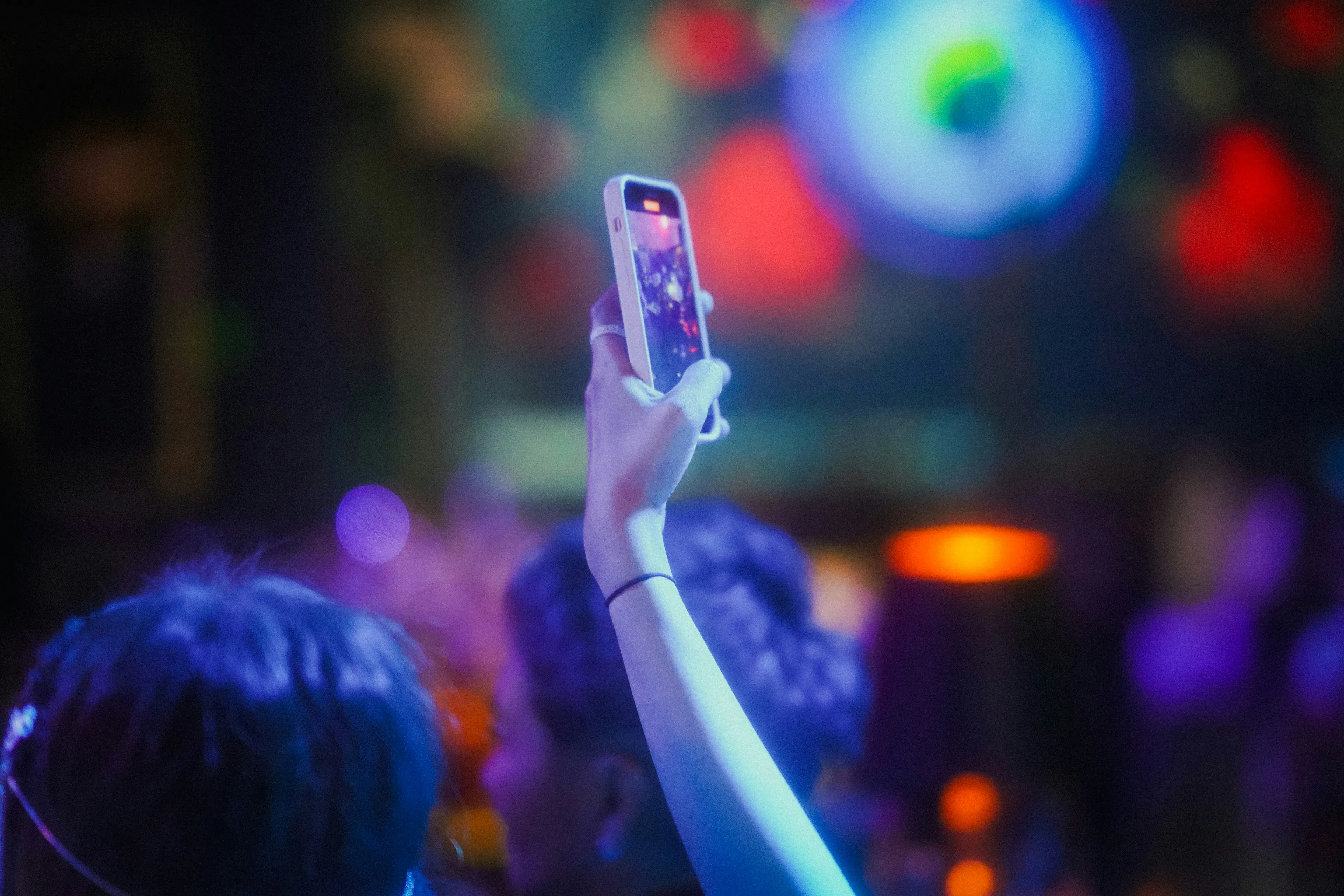 person taking video on phone at event